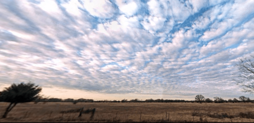 A photograph of the clouds and sky above what was once my grandparents' farm in rural east Texas.
